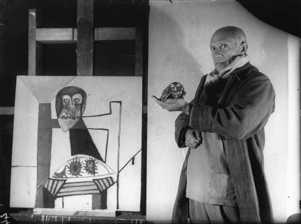Picasso with an owl and his painting Owl on a chair and sea urchins