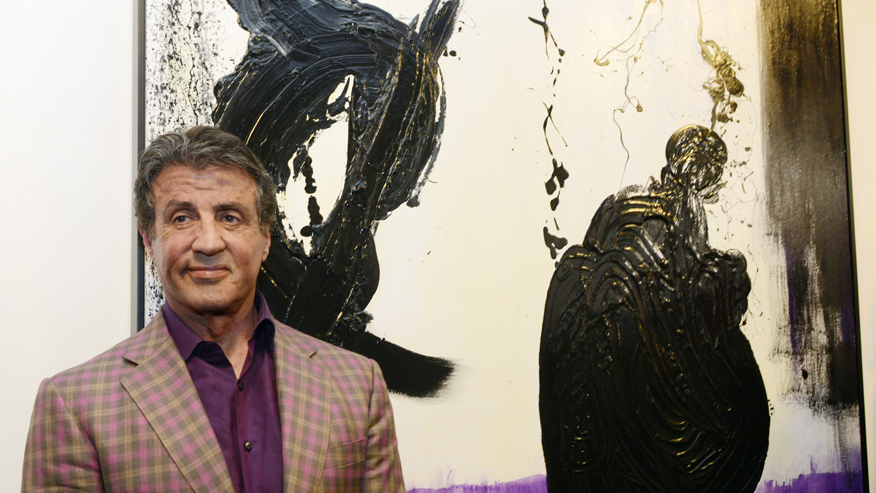 Actor and artist Sylvester Stallone poses in front of his painting, 